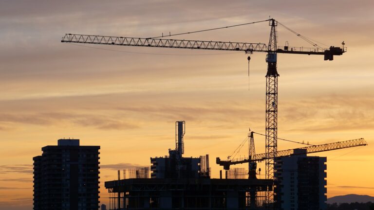 Kyrgyzstan vs UAE vs Saudi Arabia: A 2026 Comparison for Pakistani Recruitment Agencies Construction cranes silhouetted at sunset — comparing Kyrgyzstan to Gulf destinations for recruitment agencies