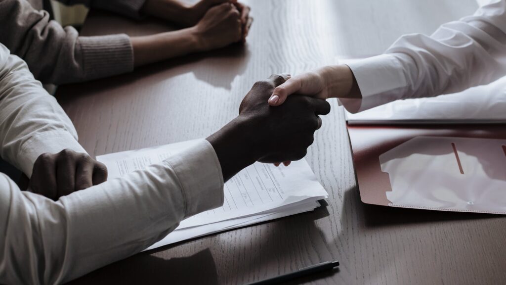 How Traveliscope Handles Kyrgyz-Side Compliance: A Walkthrough for Partner Agencies Handshake over a meeting table — Kyrgyz-side compliance walkthrough for partner agencies